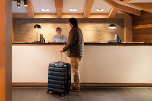 A man stands with luggage in front of the check-in desk at 168极速赛车官方开奖结果记录体彩 Resort
